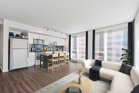 a living room with a white couch and a kitchen with a table and chairs